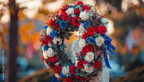 A wreath of red, white, and blue flowers is placed on a table