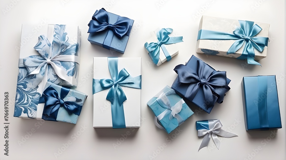 Isolated on a white background with empty space, a top view of blue and white giftboxes with a blue satin ribbon bow Isolated on a white background with empty space, a top view of blue and white giftboxes with a blue satin ribbon bow