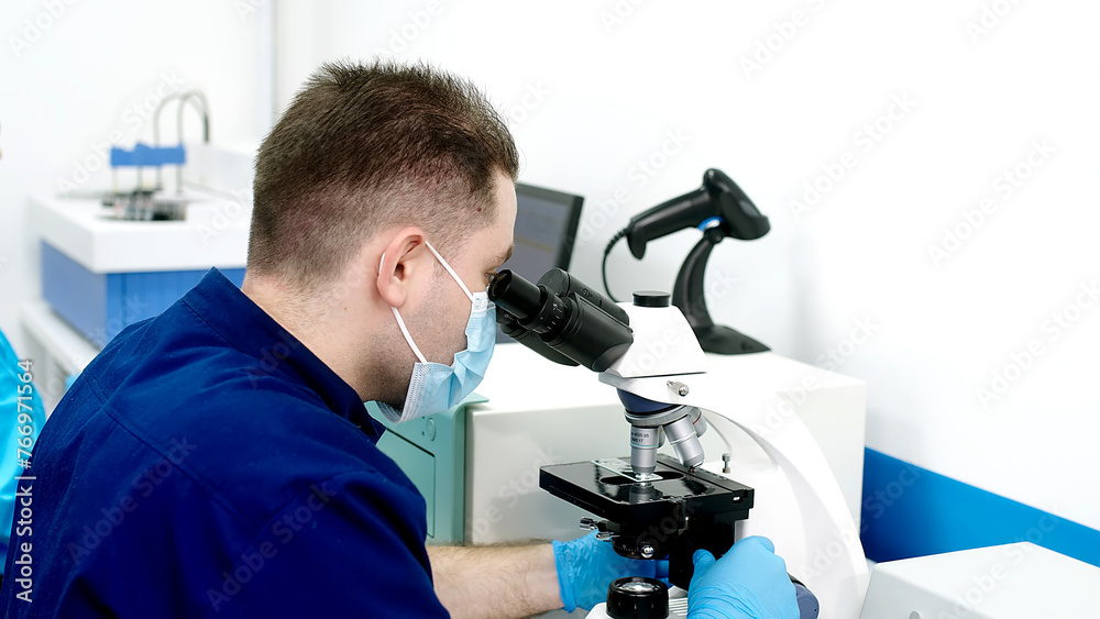 Scientist in a modern medical laboratory looking into a microscope. Microbiologist works on molecular samples in a modern laboratory with technological equipment. Scientist in a modern medical laboratory looking into a microscope. Microbiologist works on molecular samples in a modern laboratory with technological equipment.