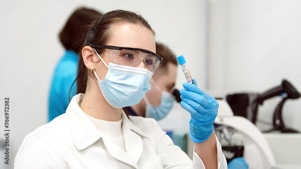 Portrait of a beautiful female scientist using a micropipette for analysis. Advanced scientific laboratory for the development of medicine, biotechnology and microbiology. Portrait of a beautiful female scientist using a micropipette for analysis. Advanced scientific laboratory for the development of medicine, biotechnology and microbiology.