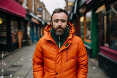 Portrait of a bearded man in an orange jacket in the city © Iigo