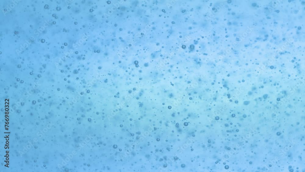 Air bubbles in a blue liquid, floating all over the frame, studio macro shot Air bubbles in a blue liquid, floating all over the frame, studio macro shot