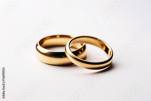 Simple yet elegant pair of gold wedding bands isolated on a white background, representing love and a timeless bond