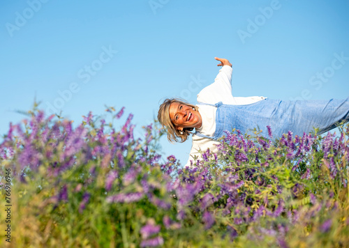 fröhliche junge Frau jubelt  in einer Blumenwiese