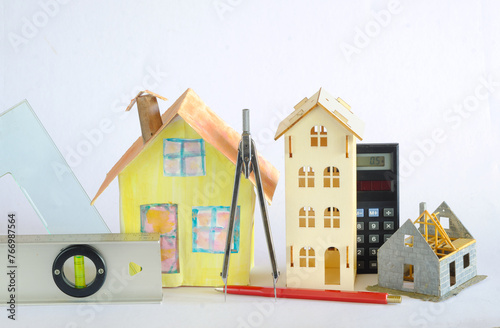 Architecture,business,finance and Construction concept. shell of an unfinished building,model home and various tools,White background,free copy space.