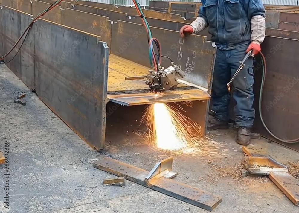 Welding of large metal structures for construction using an automatic welding machine.