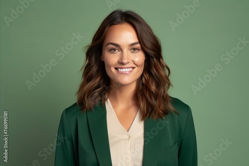 Portrait of beautiful young businesswoman smiling at camera against green background