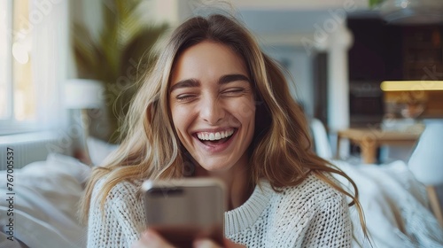 Joyful woman laughing while looking at her phone.
