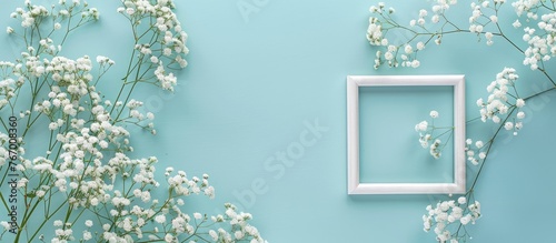 Romantic floral arrangement with white baby's breath flowers and a picture frame on a soft blue backdrop. Perfect for occasions like Valentine's Day, Easter, birthdays, Women's Day, and Mother's Day. photo
