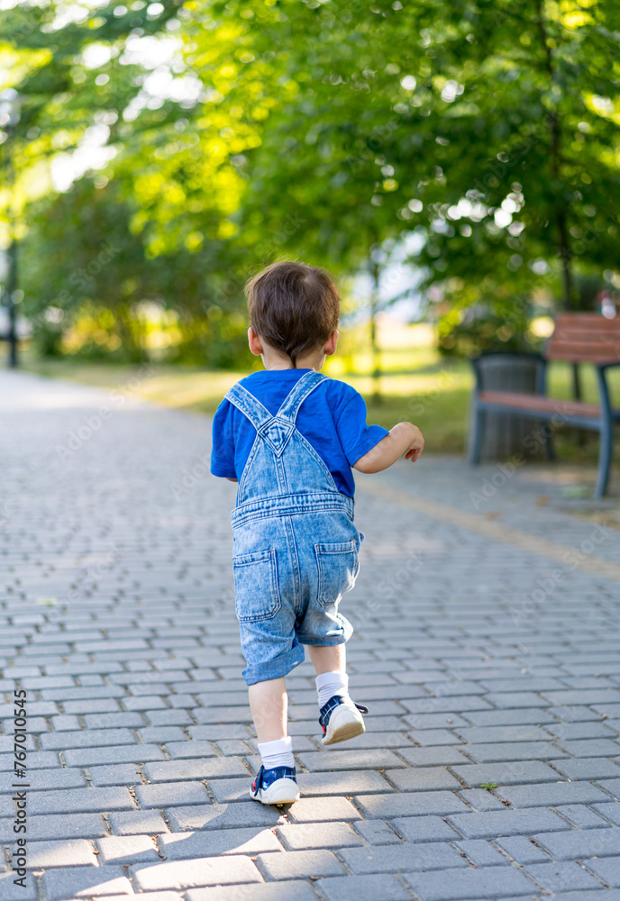 Little boy is running in the park on the pavement Little boy is running in the park on the pavement