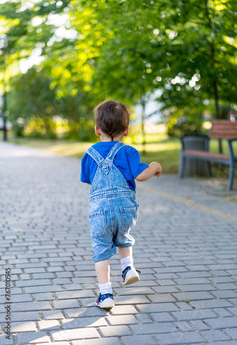 Little boy is running in the park on the pavement © Vadim