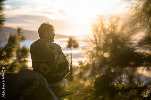 One man have relax sitting on the cliff looking clouds in background - concept of travel people and enjoy mountains valley silence - adult explore lifestyle