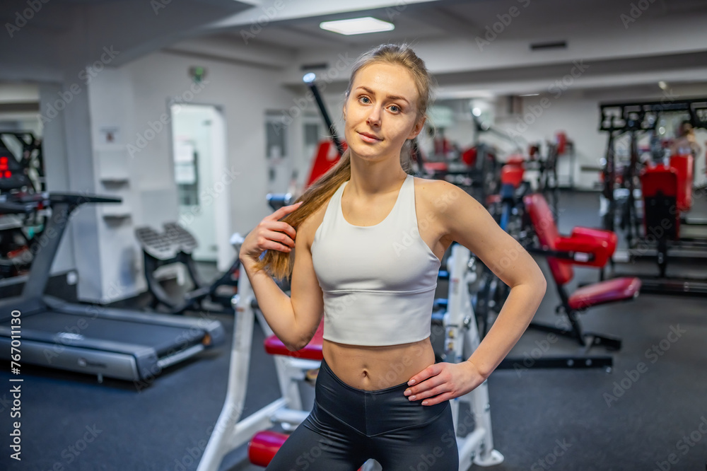 Young sporty woman wearing sportswear posing before doing exercise with fitness equipment at gym, she exercise for strong and good Young sporty woman wearing sportswear posing before doing exercise with fitness equipment at gym, she exercise for strong and good