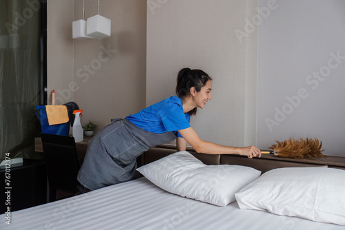cleaning service woman worker clean bedroom at hotel. housekeeper cleaner feel happy and make bed look neat. housework and housekeeping cleaning service