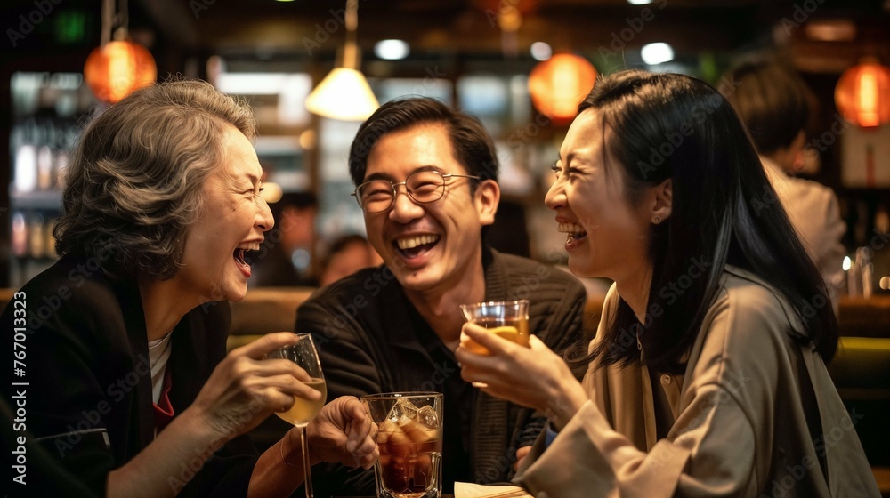 Group of Asian adults laughing and enjoying drinks together at a vibrant bar party