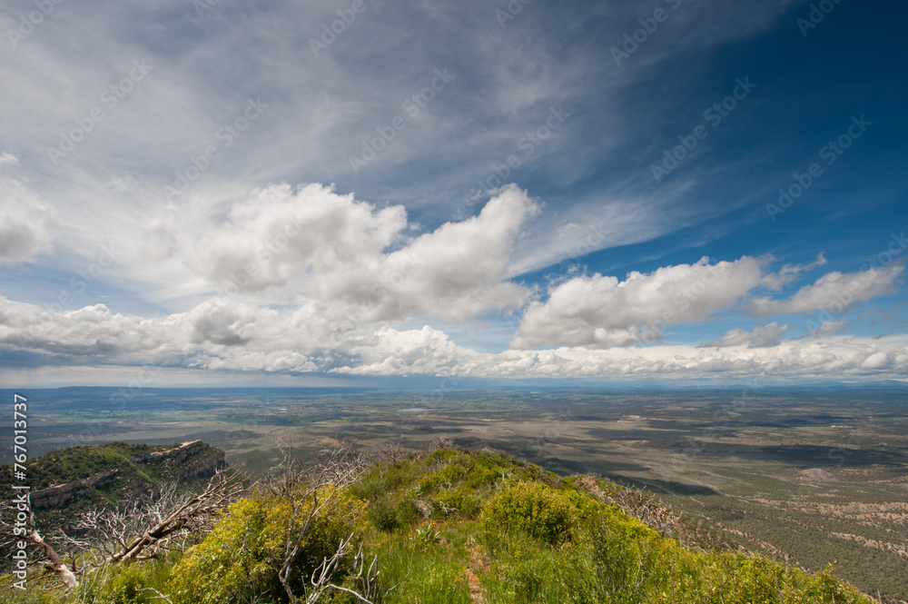 Majestic landscape showcasing expansive plains, distant mountain ridges, and dramatic cloud formations in the sky