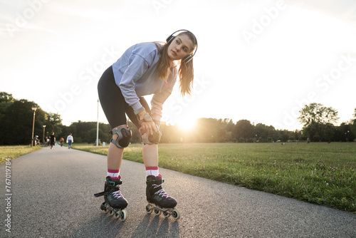 Young woman getting ready for rollerblading in the park