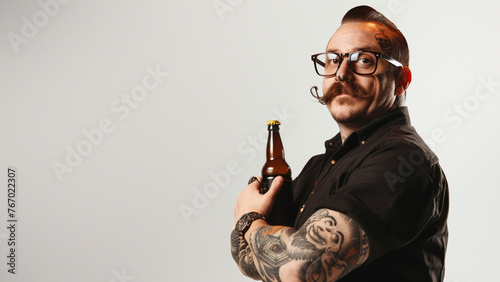 A stylish man with glasses holding a beer bottle, symbolizing a break from the conventional photo