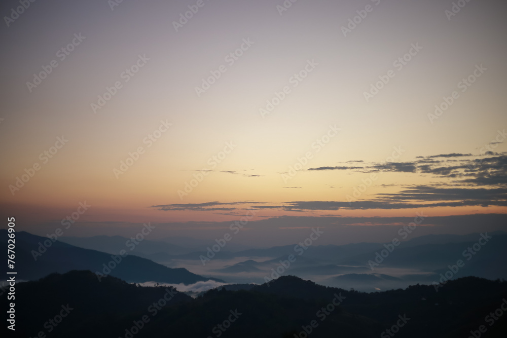 Background image of a morning landscape on a mountaintop with mountains and a sea of ​​mist before the sun rises. There is space for text.