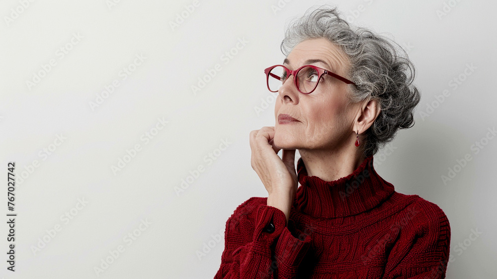 A mature woman posing in a thoughtful gesture on a pristine white background.