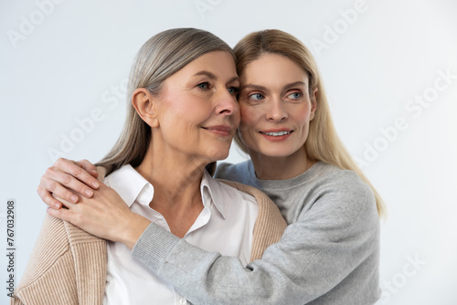 Waist up picture of mom and daughter embracing