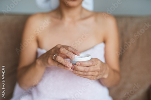 Woman Applying Moisturizer from Jar photo