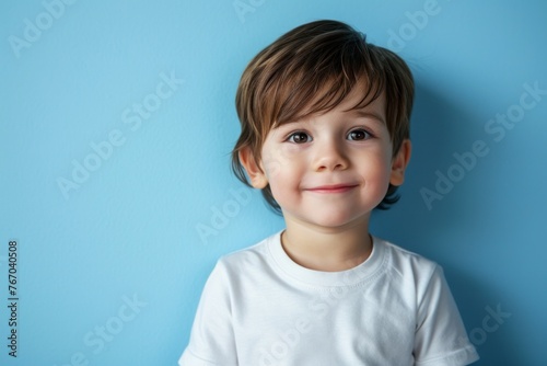 Portrait of a cute smiling little boy on a blue background.
