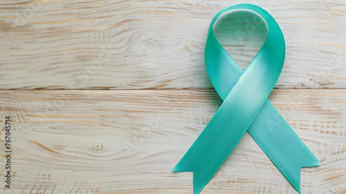 Simple teal green cancer ribbon wood background support ovarian campaign cervical  ptsd sexual assault polycystic ovary syndrome PCOS anxiety survivor research copy space header medicine event banner photo