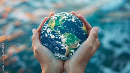NASA-provided image showing a human hand holding earth global over a blurry blue water background as a symbol of sustainable development goals (SDGs).
