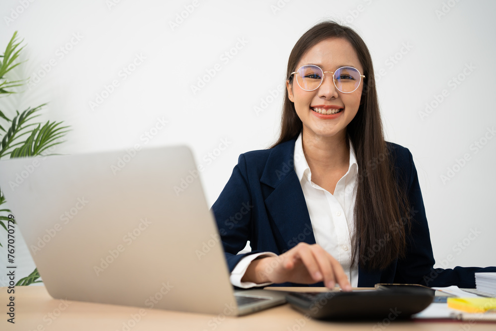 Portrait of smiling beautiful business asian woman at modern office desk using laptop to work and write notes, Business people employee freelance online marketing e-commerce telemarketing concept. Portrait of smiling beautiful business asian woman at modern office desk using laptop to work and write notes, Business people employee freelance online marketing e-commerce telemarketing concept.