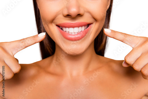 Cropped close up photo of brown-haired lady with her naked shoulders she pointer forefingers fingers on two hands on teeth make white smile isolated on pastel beige background