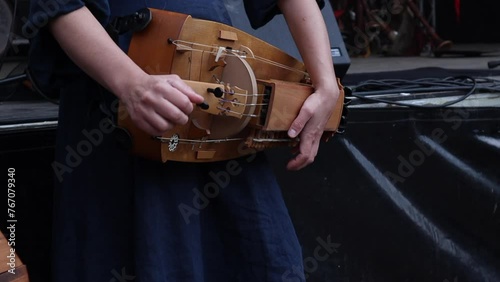 Close-up hands of a musician playing a hurdy-gurdy