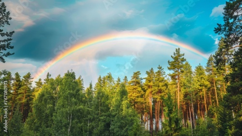 Rainbow against a background of blue sky and forest. Sky after rain