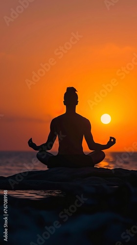 Man in yoga pose  zen meditation at sunset 