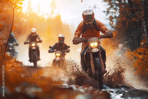 motorcycle racers on sports enduro motorcycles in off-road race riding on dirty road in nature at sunset photo