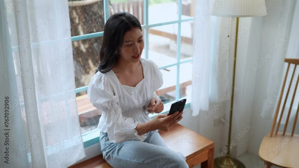 An Asian female entrepreneur working at a nearby café, engaged in focused and diligent video calls on her smartphone, showcasing remote work outside the office An Asian female entrepreneur working at a nearby café, engaged in focused and diligent video calls on her smartphone, showcasing remote work outside the office