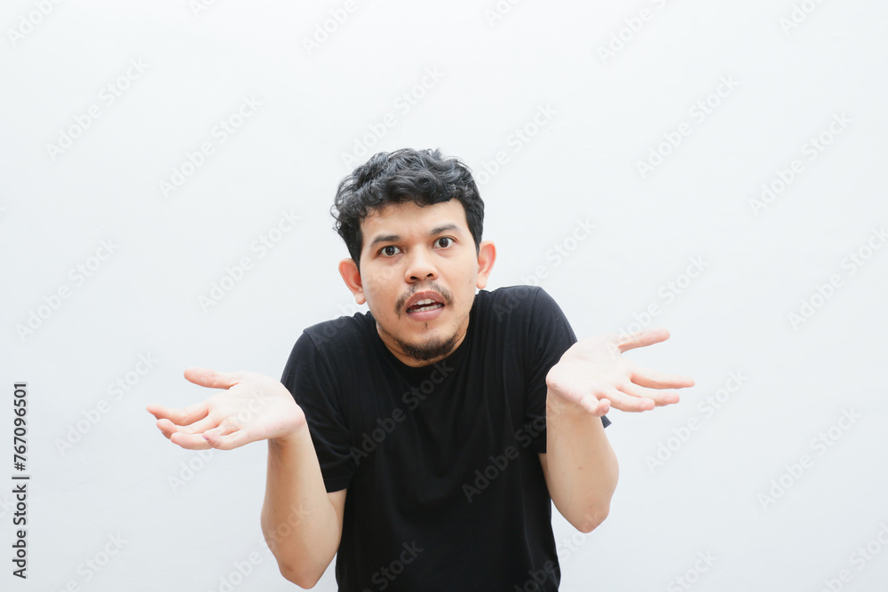 an asian man shows a curious expression with open arms an asian man shows a curious expression with open arms