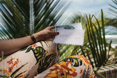 Fototapeta Naklejka Na Ścianę i Meble -  Woman holds postcards on bean in the Caribbean