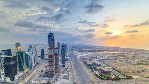 Dubai business bay towers with sunset timelapse. Rooftop view of some skyscrapers and new towers under construction.