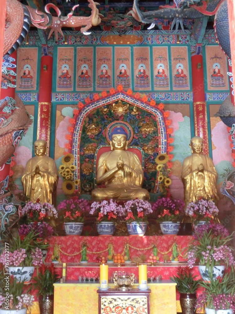 Flowers adorned the base of the Buddha statue, adding a touch of natural beauty to the sacred space.