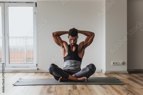 man sitting on yoga mat doing triceps extensions