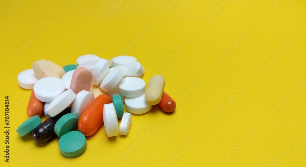 various kinds of pills arranged abstractly on a yellow background various kinds of pills arranged abstractly on a yellow background