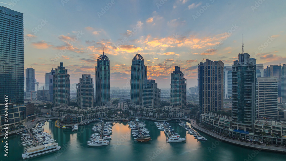 View of modern skyscrapers shining in sunrise lights timelapse in Dubai Marina in Dubai, UAE.