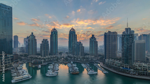 View of modern skyscrapers shining in sunrise lights timelapse in Dubai Marina in Dubai, UAE.