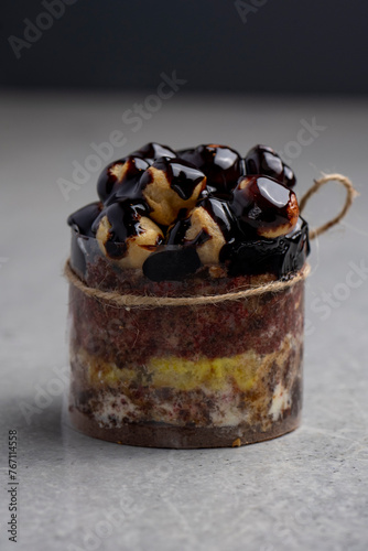 Chocolate cake with profiteroles on a gray background. Selective focus.