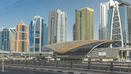 View of Jumeirah lakes towers skyscrapers and metro sration timelapse with traffic on sheikh zayed road. © neiezhmakov