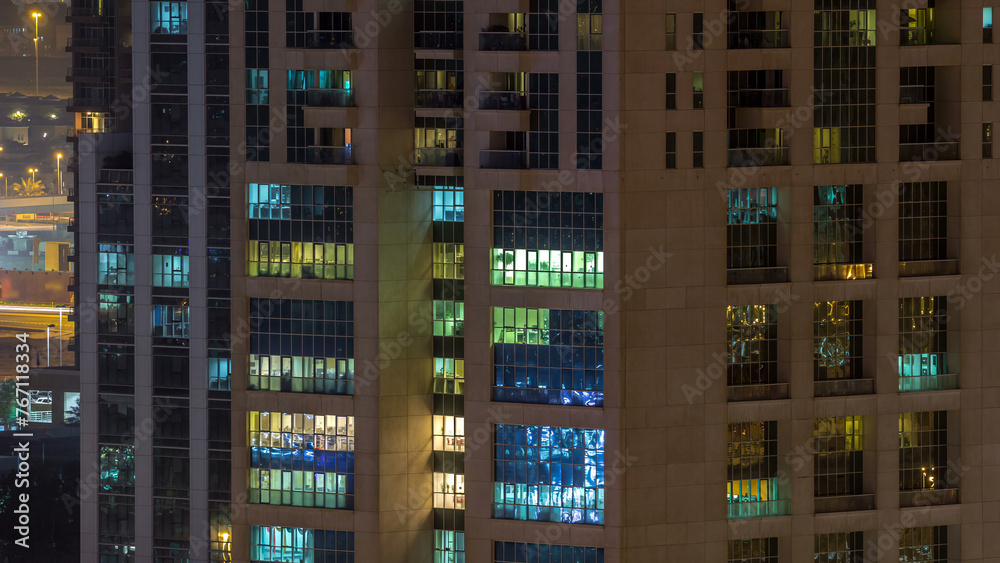 Windows of the multi-storey building of glass and steel lighting inside and moving people within timelapse Windows of the multi-storey building of glass and steel lighting inside and moving people within timelapse