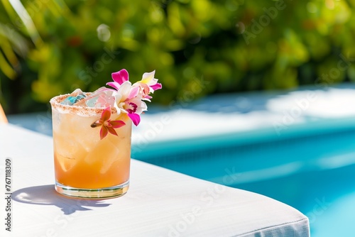 cocktail with floral garnish on a poolside lounger