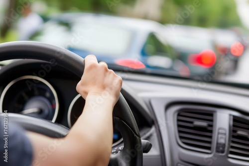 closeup of hands on steering wheel in a line of cars © studioworkstock