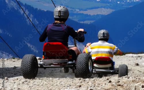A young couple descends on carts from the hill to the valley at the top of Chopok Slovakia